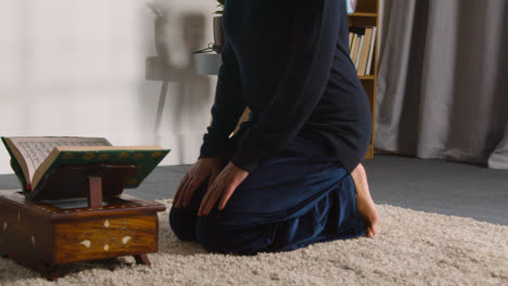 Close-Up-Of-Muslim-Woman-At-Home-Kneeling-And-Reciting-From-The-Quran